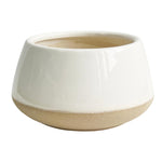 A round, ceramic planter with a wide opening and a smooth, white crackle-glazed upper half. The bottom half is a textured, unglazed beige color, creating a two-tone design. This Phoebe Ceramic Round Vase - Cream from MyHomeDecor.ca boasts a modern, minimalist aesthetic in cream and beige tones.