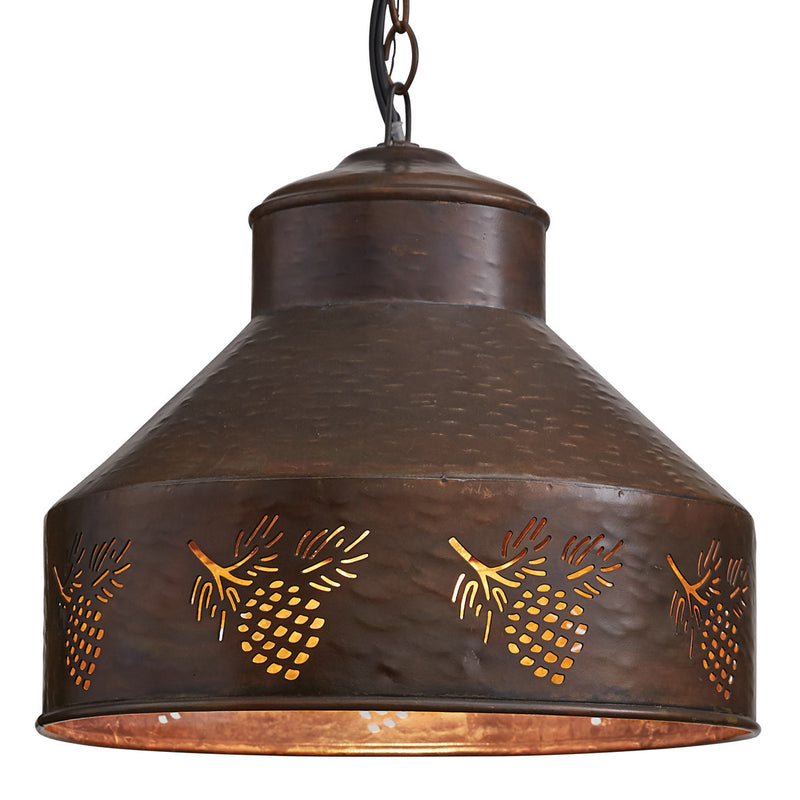 A rustic metal pendant light with a hammered copper finish, featuring cutout pinecone accents around its cylindrical lower section. A warm glow emanates from within, highlighting the intricate pinecone patterns. The fixture hangs by a dark chain, exuding the charm of a rustic chandelier. Introducing the Hanging Lamp - Pinecone by MyHomeDecor.ca.