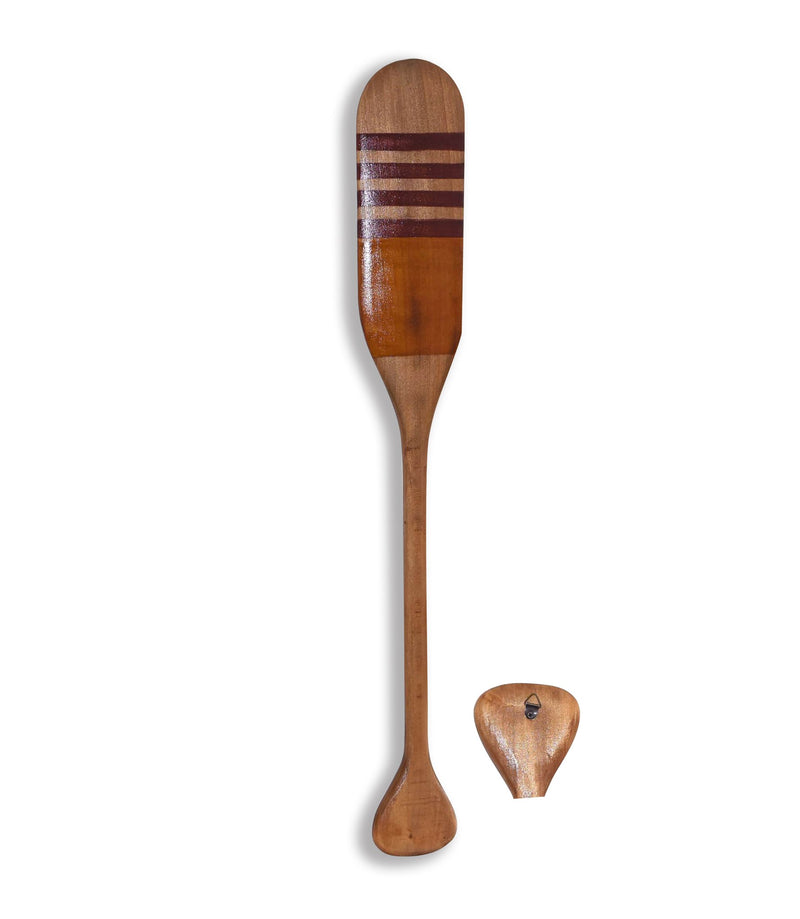 A single wooden paddle featuring a striped design with three maroon lines near the top. The MyHomeDecor.ca Wooden Paddle - Matte Orange & Yellow has a long handle and rounded blade. Below the paddle is a separate small wooden piece, shaped like a guitar pick with a hole in the center, adding to its decorative charm.