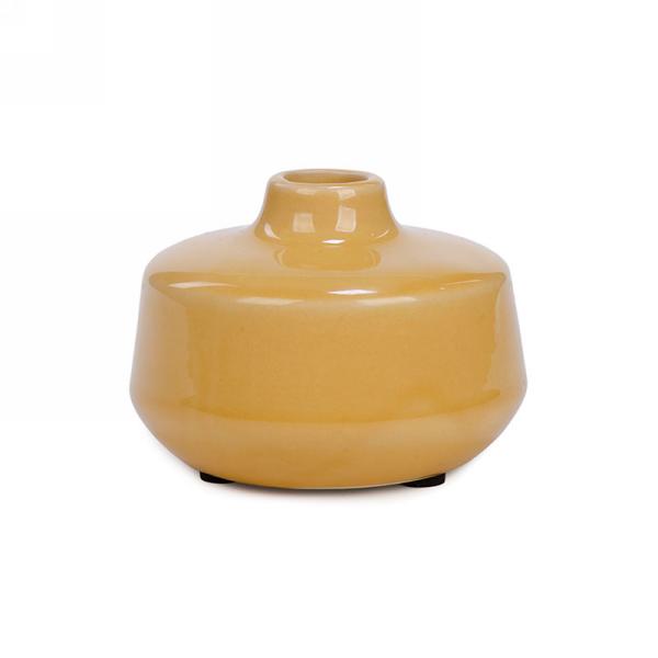 A small, glossy, 4.5 inch ceramic vase in a mustard-yellow hue with a wide, rounded body and narrow opening. The vase has a smooth, shiny finish and sits on a flat base. It's the Flat Ceramic Vase - Mustard Medium by MyHomeDecor.ca.