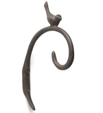 A rustic, wall-mounted cast iron hook designed with a small bird perched on top, featuring a curved arm with a looped end. The **Curl Hook with Bird - Brown** from **MyHomeDecor.ca** has a textured, weathered appearance and is perfect for enhancing your outdoor space. It is attached to the wall with two screws.